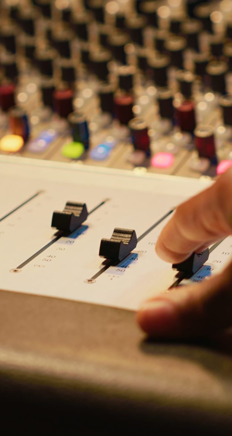Artist composer creating a new song on his electro guitar in studio, recording tracks in control room using mixing console and amplifier. Songwriter creates new music for his album. Camera A.