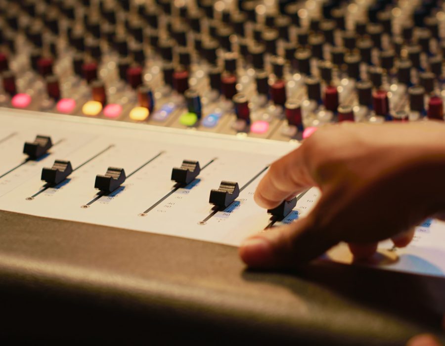 Artist composer creating a new song on his electro guitar in studio, recording tracks in control room using mixing console and amplifier. Songwriter creates new music for his album. Camera A.